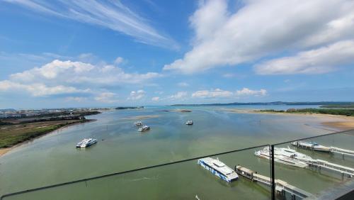 a river with boats in it on a cloudy day at Palam Mansion at Apartment One Residence in Batam Center