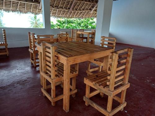 a wooden table and chairs in a room at Jodari Hotel Nungwi in Nungwi