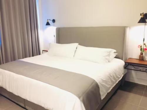 a large white bed in a hotel room at Urban Gran Plaza in Guadalajara