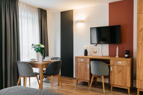 a hotel room with a table with chairs and a television at ORSO Rooms & Apartments - LoftAffair Collection in Warsaw