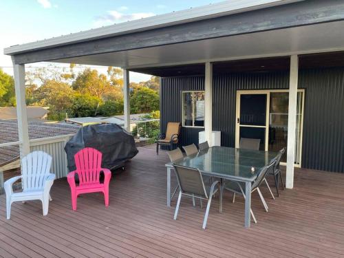 a deck with chairs and a table with a glass top at Coastal Retreat, 400 Metres to beach in Cowes