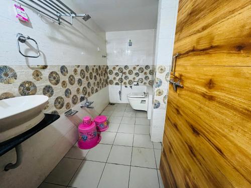 a bathroom with a sink and a toilet and a door at FabHotel Lake View I in Dabhoi