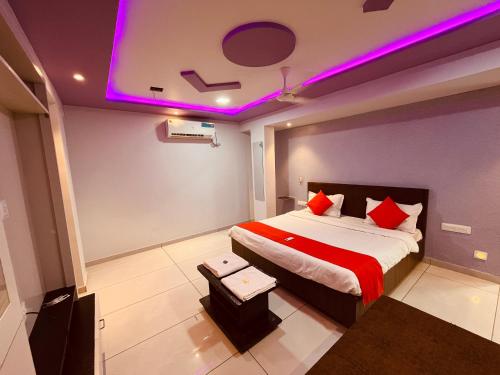 a bedroom with a bed with purple lights on the ceiling at FabHotel Lake View I in Dabhoi