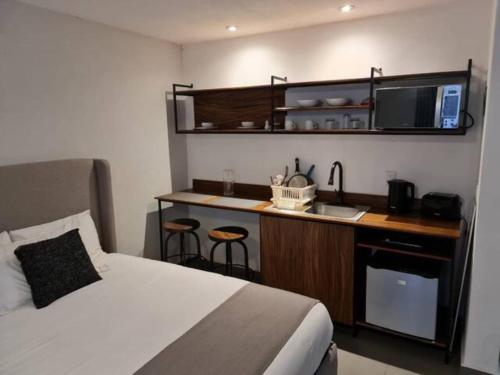 a bedroom with a bed and a kitchen with a sink at Urban Gran Plaza in Guadalajara
