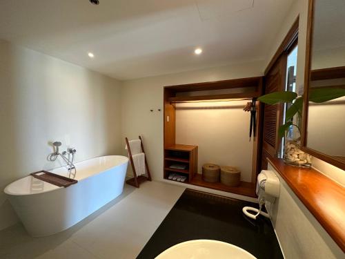 ein Badezimmer mit einer Badewanne, einem WC und einem Waschbecken in der Unterkunft Bluewater Maribago Beach Resort in Mactan