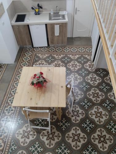 una mesa con flores en la parte superior de un suelo de baldosa en Casa Vacanze Le Doi Salentine en Parabita