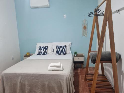 ein Schlafzimmer mit einem Bett und einem Stuhl mit Handtüchern darauf in der Unterkunft Casa Pé Na Areia RN in Touros