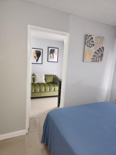 um quarto com uma cama e um sofá verde em Comfy and cozy em Kingston