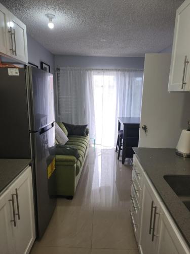 a living room with a couch and a kitchen at Comfy and cozy in Kingston