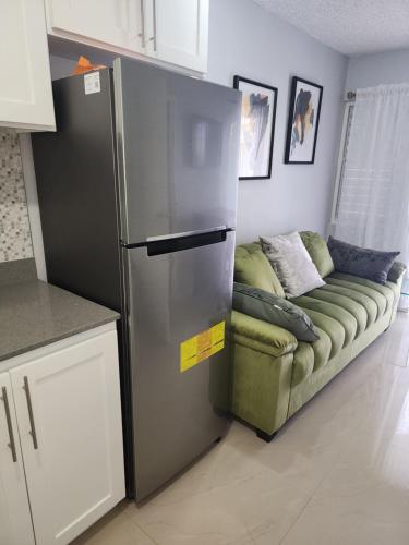 a refrigerator in a kitchen with a couch next to it at Comfy and cozy in Kingston