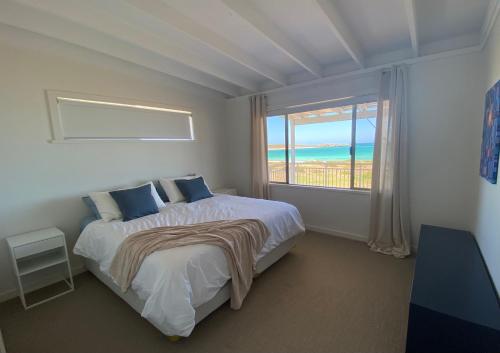 1 dormitorio con cama y ventana grande en Ospreys View - Relaxed Coastal Vibe, en Lancelin