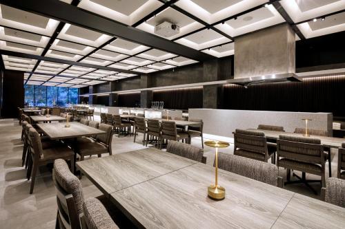 a dining room with wooden tables and chairs at Hotel JAL City Fukuoka Tenjin in Fukuoka