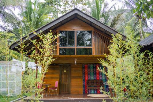 a small wooden cabin with a window and a table at Daya Farm and Adventure in Banay-Banay