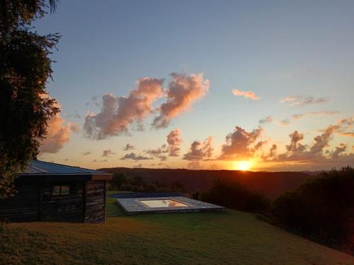 a view of the sunset from the backyard of a house at Fire Fly Cabin in Knysna