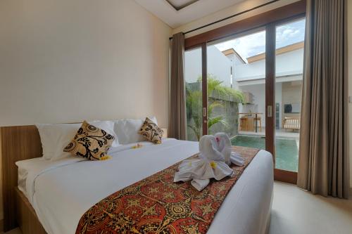 a bedroom with a bed with a stuffed bird on it at Lodji Ubud in Ubud