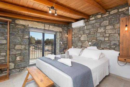 1 dormitorio con cama y pared de piedra en La Casa Di Pietre 2 en Kiotari