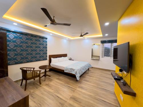a bedroom with a bed and a flat screen tv at JP RESIDENCY in Yelagiri