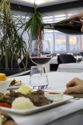 a bottle of wine is being poured into a glass at Cavit Duvan Prestige Hotel in Edirne