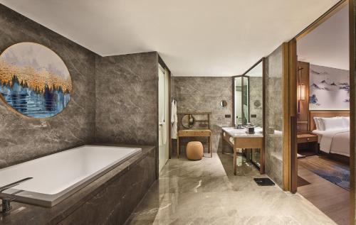 成都市にあるCrowne Plaza Chengdu Wuhou by IHGのバスルーム(バスタブ付)、ベッドルーム1室が備わります。