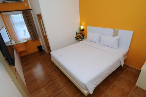 Ένα ή περισσότερα κρεβάτια σε δωμάτιο στο Ruma Ruma Hotel Kenten - Palembang