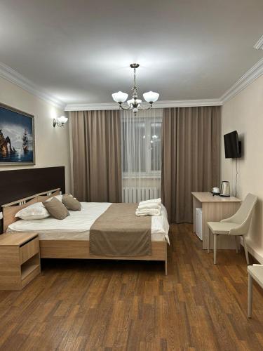 a bedroom with a large bed and a desk at Skif Hotel in Astana