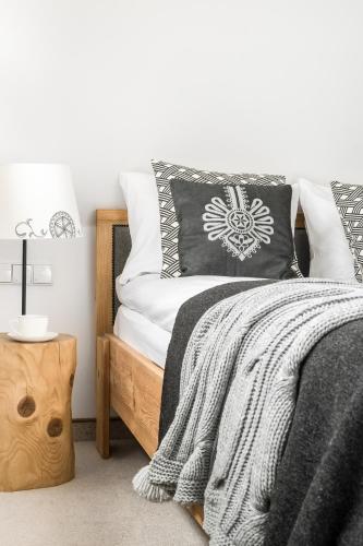 a bedroom with a bed with a black and white blanket at Villa 11 Folk & Design in Zakopane
