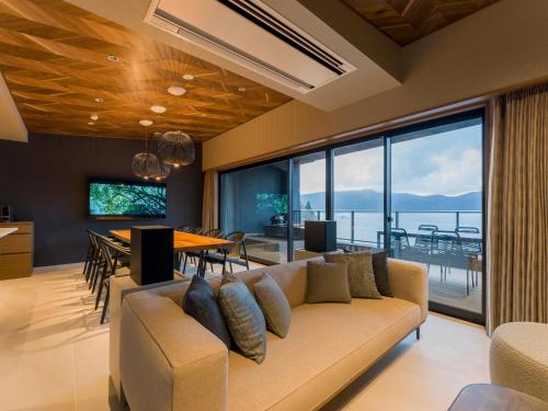 a living room with a couch and a dining table at Rakuten STAY FUJIMI TERRACE Hakone Ashinoko in Hakone