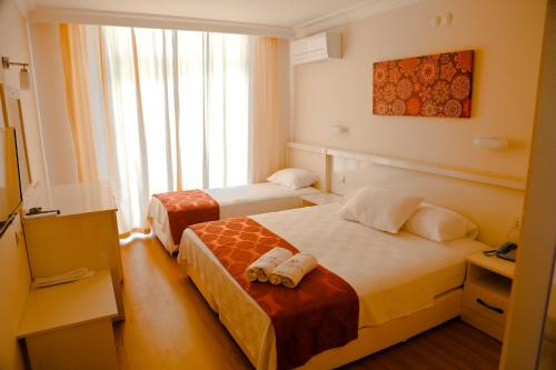 Habitación de hotel con 2 camas y ventana en Nagidos Hotel, en Bozyazı