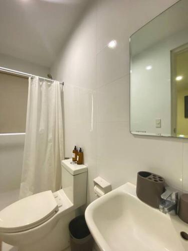 bagno bianco con servizi igienici e lavandino di Richwell de Maison at Pontefino Prime Elite a Città di Batangas
