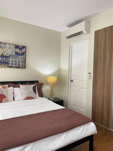una camera con un grande letto e una porta bianca di Richwell de Maison at Pontefino Prime Elite a Città di Batangas