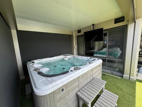 a jacuzzi tub in a room with a tv at Lakeside Retreat in Gold Coast