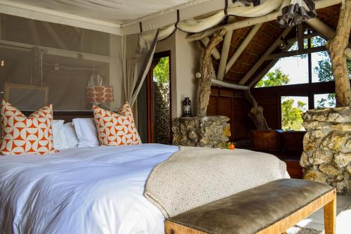 a bedroom with a bed with orange and white pillows at Mosaic Lagoon Lodge in Stanford