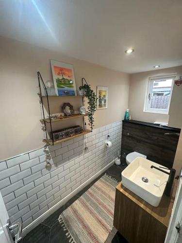 a bathroom with a white toilet and a sink at Ivy Villa in Trench