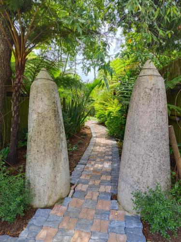 a walkway with three stone pillars in a garden at Dar Amane Guest House in Graskop
