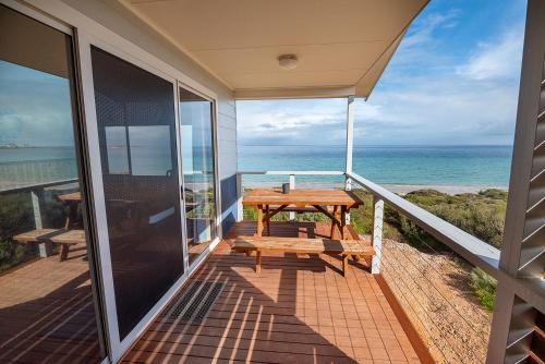 a balcony with a picnic table and the ocean at Ceduna Shelly Beach Caravan Park in Ceduna