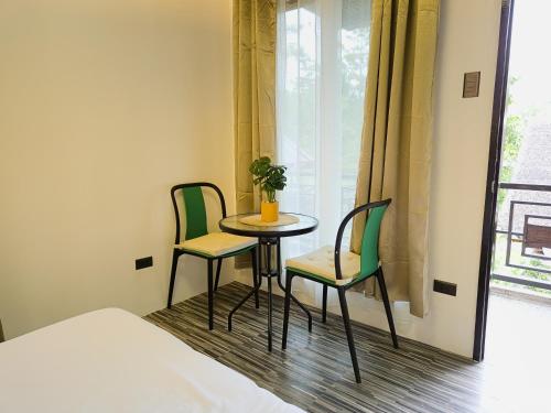 a small table and two chairs in a room with a window at Daya Farm and Adventure in Banay-Banay