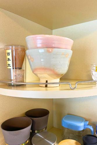 a shelf with bowls and other items on it at The Global West in Niihama