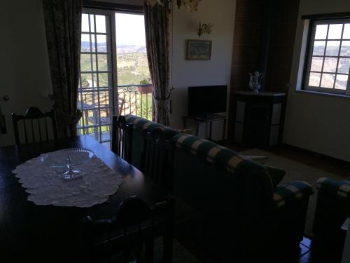 a dining room with a table and a couch at Quinta dos Espinheiros in Provesende