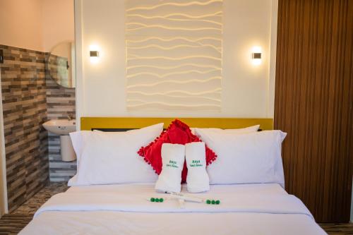 a bedroom with a white bed with red pillows at Daya Farm and Adventure in Banay-Banay