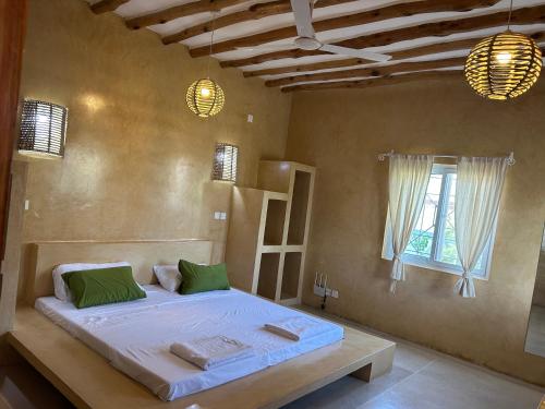 una camera con un letto in una stanza con una finestra di Nyumbani Tamu a Watamu