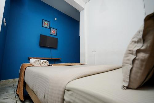 two beds in a room with a blue wall at Twinn Waves Calicut in Kozhikode