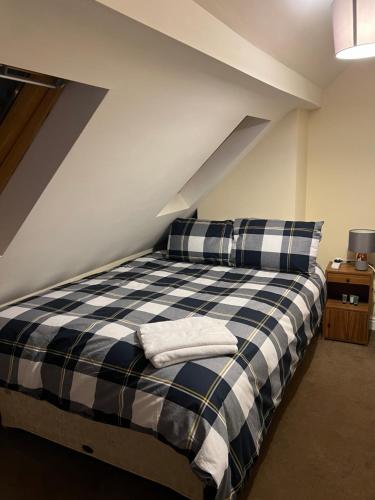 a bedroom with a black and white bed with two pillows at HAMS LODGE - - Strictly Only ONE GUEST ALLOWED IN ONE ROOM A SECOND ACCOMPANYING PERSON WILL NOT BE ALLOWED INTO THE PROPERTY in Birmingham