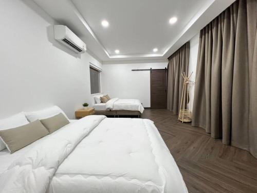 a white bedroom with a large bed and a couch at Arom Pool Villa Pattaya 2 in Na Jomtien