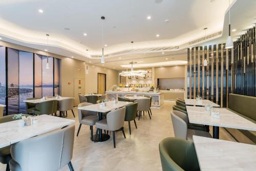 a restaurant with tables and chairs and a bar at Atour Hotel Hangzhou Zhuantang Songcheng Academy of Fine Arts in Hangzhou