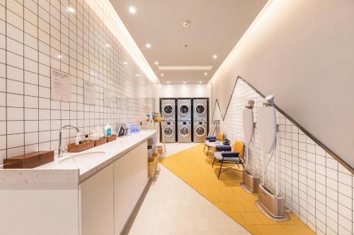 廣州的住宿－广州黄埔萝岗科学城亚朵酒店，浴室设有水槽和带椅子的柜台。