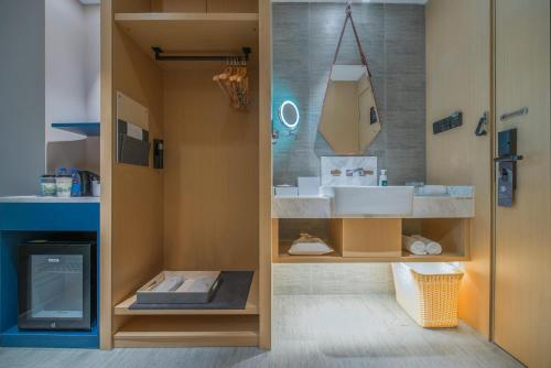 La salle de bains est pourvue d'un lavabo et d'un miroir. dans l'établissement Atour Hotel Guangzhou Sanyuanli, à Canton
