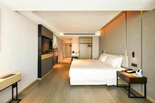 a bedroom with a large white bed and a desk at Atour Hotel Beijing Tongzhou Liyuan Subway Station in Tongzhou