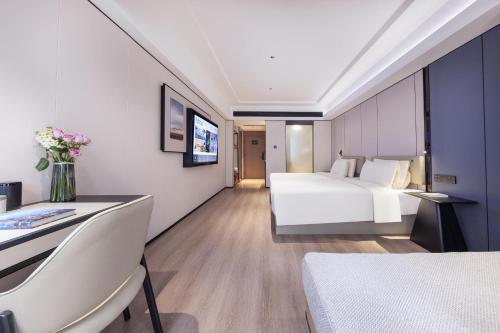 a hotel room with a bed and a vase of flowers at Atour X Hotel Shenzhen Luohu Sungang Baoneng Center in Shenzhen