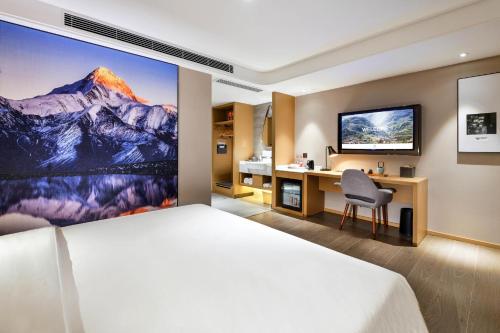 Cette chambre comprend un lit et un bureau. dans l'établissement Atour Hotel Chengdu Jinli Hongpailou Subway Station, à Chengdu