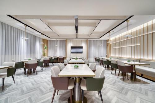 a conference room with tables and chairs and a tv at Atour Hotel Hangzhou Jiubao Passenger Transport Center Jiutian Huanbei in Hangzhou